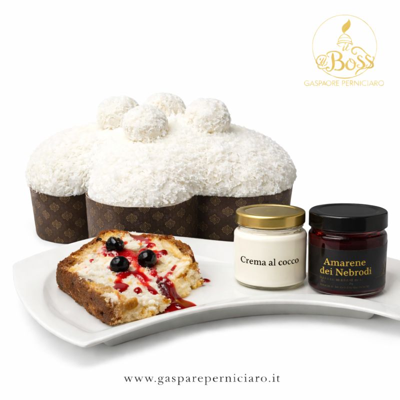 Colomba artigianale Cocco e Amarene Il Boss Gaspare Perniciaro con glassa al cocco, fettina servita su piatto elegante, vasetto di crema al cocco e vasetto di amarene dei Nebrodi in confezione premium su sfondo bianco professionale